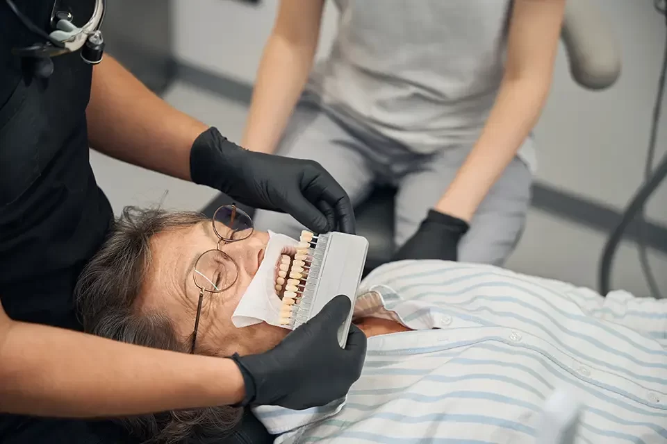 dentist-wearing-protective-gloves-selects-color Step-by-Step Guide to the Dental Implant Procedure