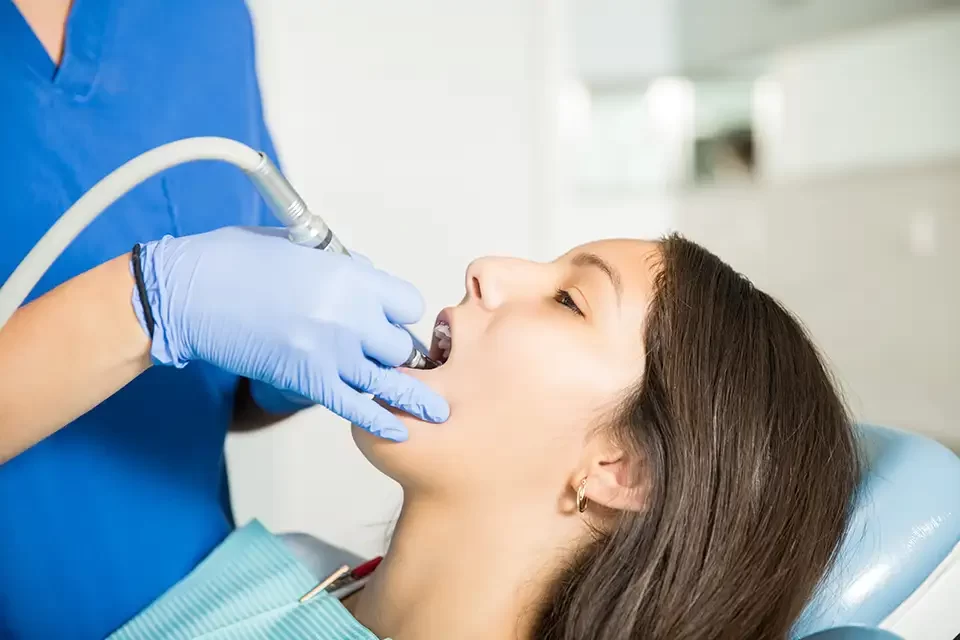 girl-receiving-treatment-with-tool-from-dentist At-Home Teeth Cleaning Methods